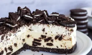 Pyszny sernik oreo na zimno, udekorowany pokruszonymi ciasteczkami i całymi oreo. Idealny deser dla miłośników czekolady.