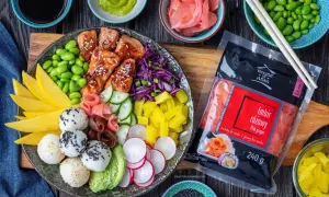 Kolorowy bowl z kawałkami łososia w sosie, ryżowymi kulkami, mango, awokado, ogórkiem, rzodkiewką, edamame i marynowanym imbirem.