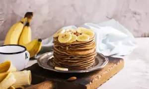 Stos naleśników z plasterkami banana i orzechami. Idealny pomysł, co zrobić z bananów na pyszne śniadanie.