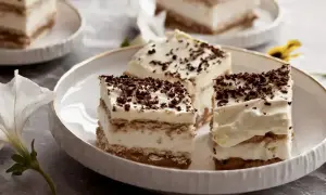 Pyszne, tanie ciasto bez pieczenia z herbatnikami, przełożone kremem i posypane czekoladą. Idealne na deser!