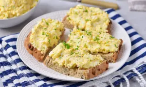Pyszna pasta jajeczna z twarogiem na chlebie, posypana szczypiorkiem. Idealna na śniadanie lub przekąskę.