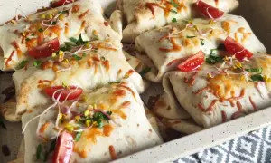 Pyszna tortilla na ciepło z piekarnika, zapieczona z serem, pomidorkami i kiełkami. Idealna na szybki obiad.