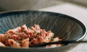 Gorący makaron z tuńczykiem w kremowym sosie, parujący w misce. Idealny na szybki obiad.