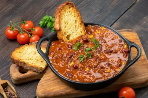 Gęste chili con carne z fasolą i kukurydzą, podane z chrupiącym pieczywem. Idealny obiad na dwa dni, który rozgrzeje i nasyci.