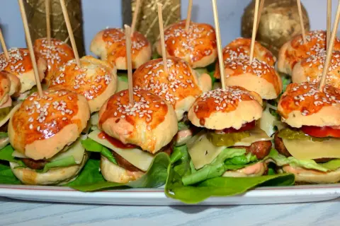 Mini burgery z kurczakiem, idealne na imprezę. Każdy ma sezamową bułeczkę, soczystego kotleta i świeże dodatki.