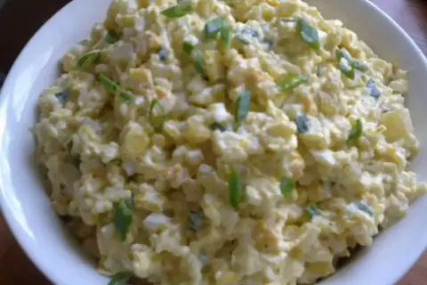 Szybka sałatka z ryżem i jajkiem, z dodatkiem szczypiorku, w białej misce. Idealna na szybki lunch.