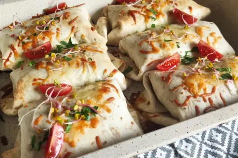 Pyszna tortilla na ciepło z piekarnika, zapieczona z serem, pomidorkami i kiełkami. Idealna na szybki obiad.