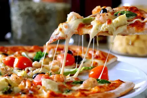 Rozciągający się ser z ciasta na pizzę z krewetkami, pomidorkami i oliwkami. Idealne na wspólny wieczór.