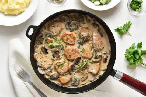 Aksamitne polędwiczki w sosie pieczarkowym, udekorowane rozmarynem i natką, podane z puree ziemniaczanym.