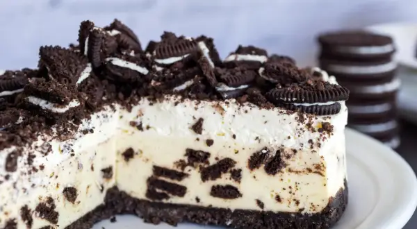 Pyszny sernik oreo na zimno, udekorowany pokruszonymi ciasteczkami i całymi oreo. Idealny deser dla miłośników czekolady.
