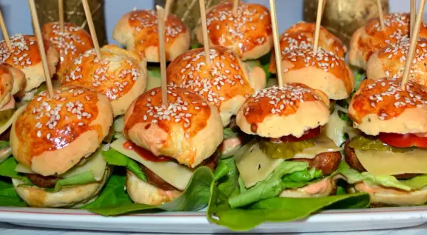 Mini burgery z kurczakiem, idealne na imprezę. Każdy ma sezamową bułeczkę, soczystego kotleta i świeże dodatki.