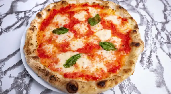Idealna pizza neapolitańska przepis: klasyczna Margherita z pomidorami, mozzarellą i bazylią, wypieczona na chrupko.