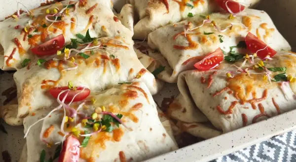 Pyszna tortilla na ciepło z piekarnika, zapieczona z serem, pomidorkami i kiełkami. Idealna na szybki obiad.