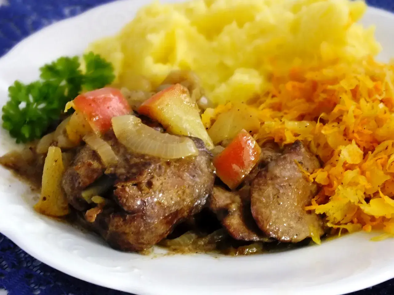 Pyszna wątróbka z jabłkiem, duszona z cebulką, podana z puree ziemniaczanym i surówką z marchewki.