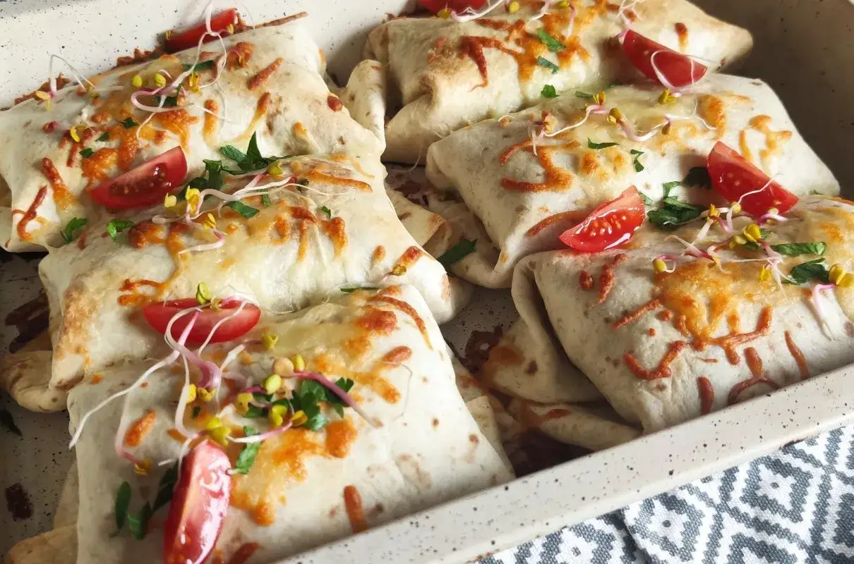 Pyszna tortilla na ciepło z piekarnika, zapieczona z serem, pomidorkami i kiełkami. Idealna na szybki obiad.