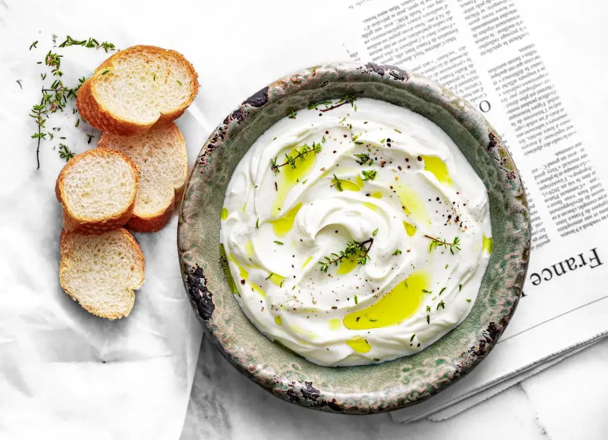 Labneh co to? Kremowy, gęsty serek jogurtowy, polany oliwą, z ziołami i pieprzem, podany z kromkami chleba.