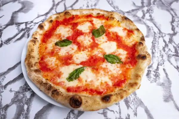 Idealna pizza neapolitańska przepis: klasyczna Margherita z pomidorami, mozzarellą i bazylią, wypieczona na chrupko.