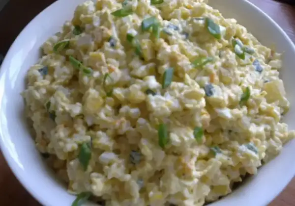 Szybka sałatka z ryżem i jajkiem, z dodatkiem szczypiorku, w białej misce. Idealna na szybki lunch.